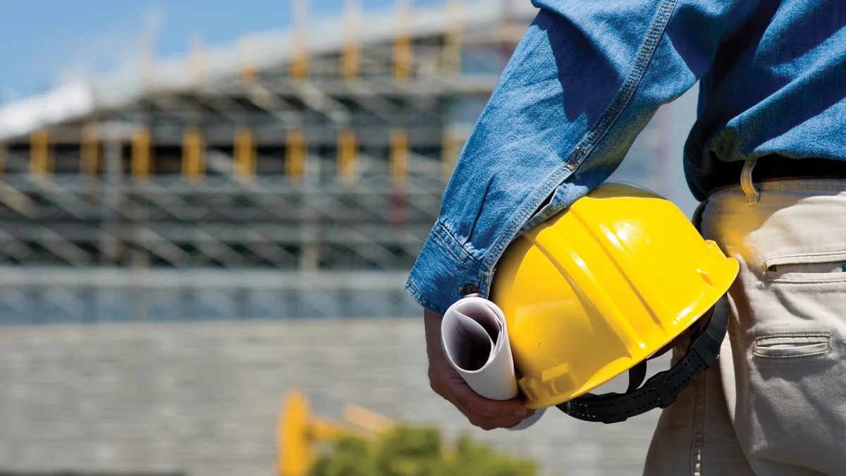Imagen ilustrativa de un profesional de construcción con casco y planos